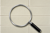 Magnifying glass on a beige tiled background
